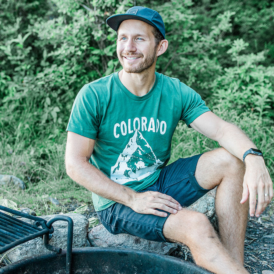 man wearing green colorado live free stay wild shirt