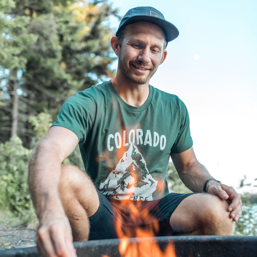 man wearing green colorado live free stay wild shirt