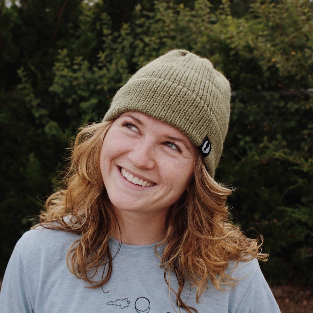 smiling woman wearing light spruce green ahab knitted beanie