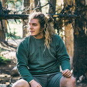 Man wearing green sweatshirt with trees 