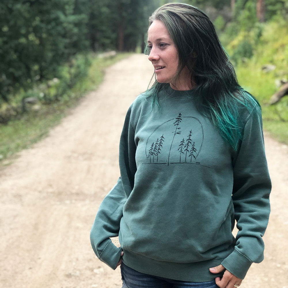 woman wearing green sweatshirt with trees