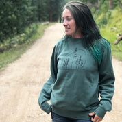 woman wearing green sweatshirt with trees 