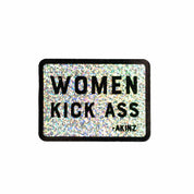 Glittery sticker with 'WOMEN KICK ASS' text on a white background