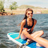 woman paddle boarding wearing a navy colorado flag tank top 