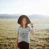 woman wearing colorado wildflowers sage scoop neck top and sun hat