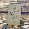 8% salty faux leather journal with octopus, ship, and bottle lying on wooden table.