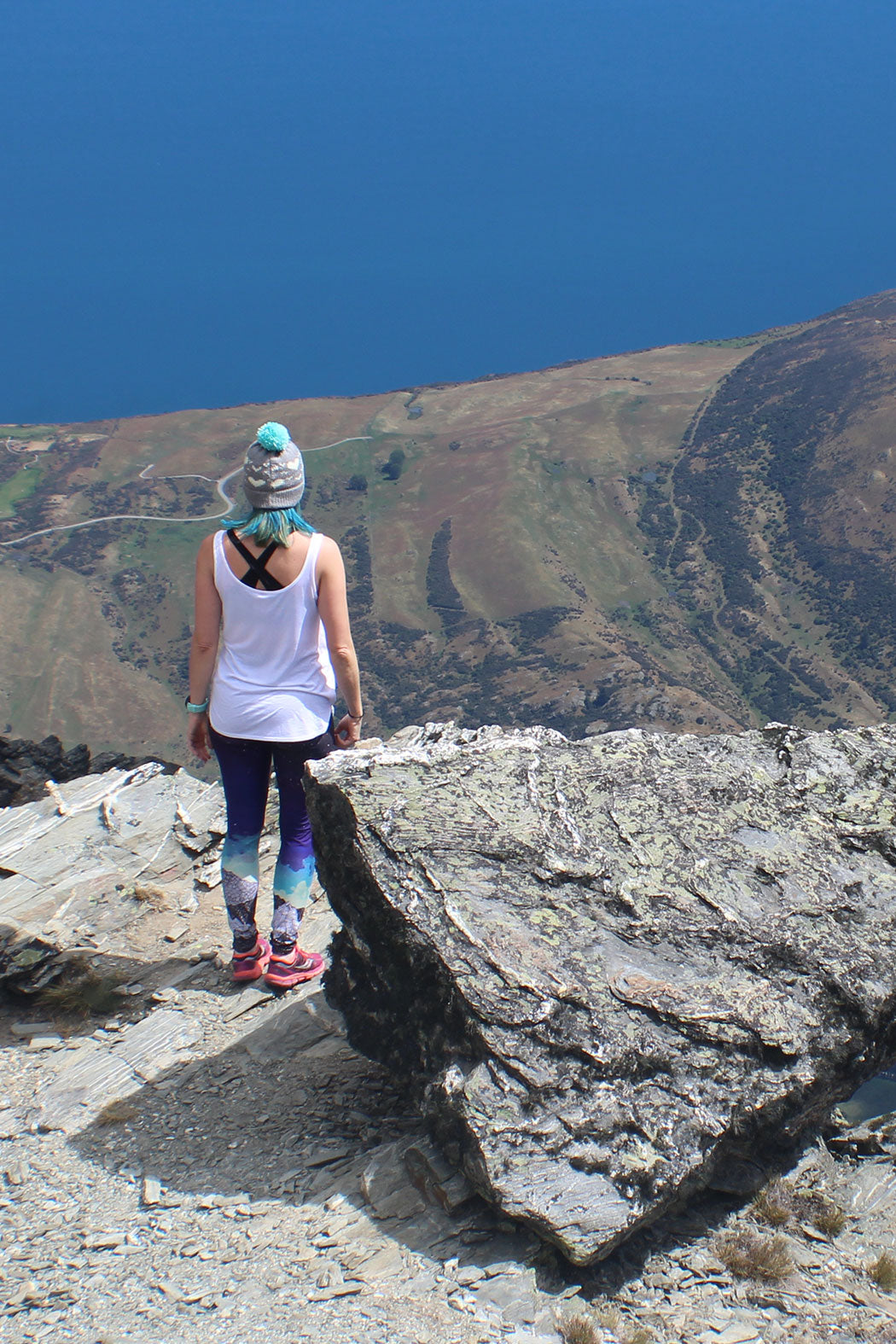 woman wearing yoga leggings at the top of a mountain 
