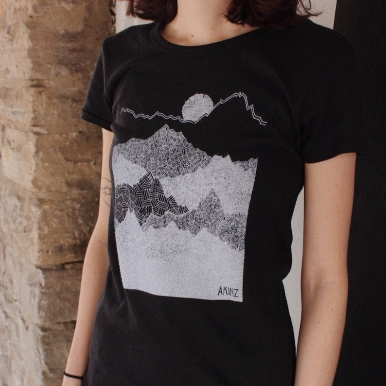 Closeup of geometric mountains "Ascend" design hand printed on a black womens tee